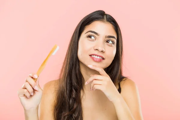 Young Indian Woman Holding Toothbrush Looking Sideways Doubtful Skeptical Expression — 스톡 사진