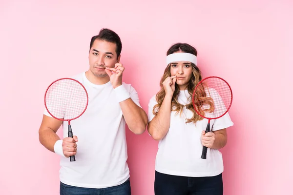Casal Jovem Jogando Badminton Isolado Com Dedos Nos Lábios Mantendo — Fotografia de Stock