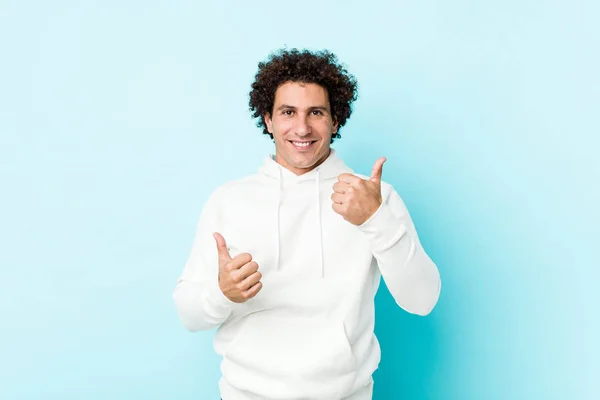 Joven Deportista Sobre Fondo Azul Levantando Ambos Pulgares Hacia Arriba — Foto de Stock