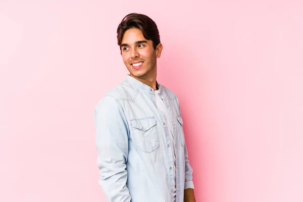 Young Caucasian Man Posing Pink Background Isolated Looks Aside Smiling — Stock Photo, Image