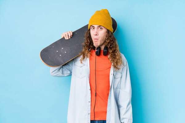Young caucasian skater man isolated shrugs shoulders and open eyes confused.