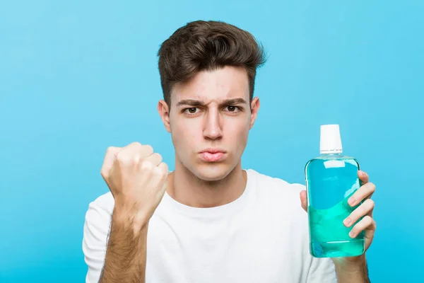 Young Caucasian Man Holding Mouthwash Showing Fist Camera Aggressive Facial — Stock Photo, Image