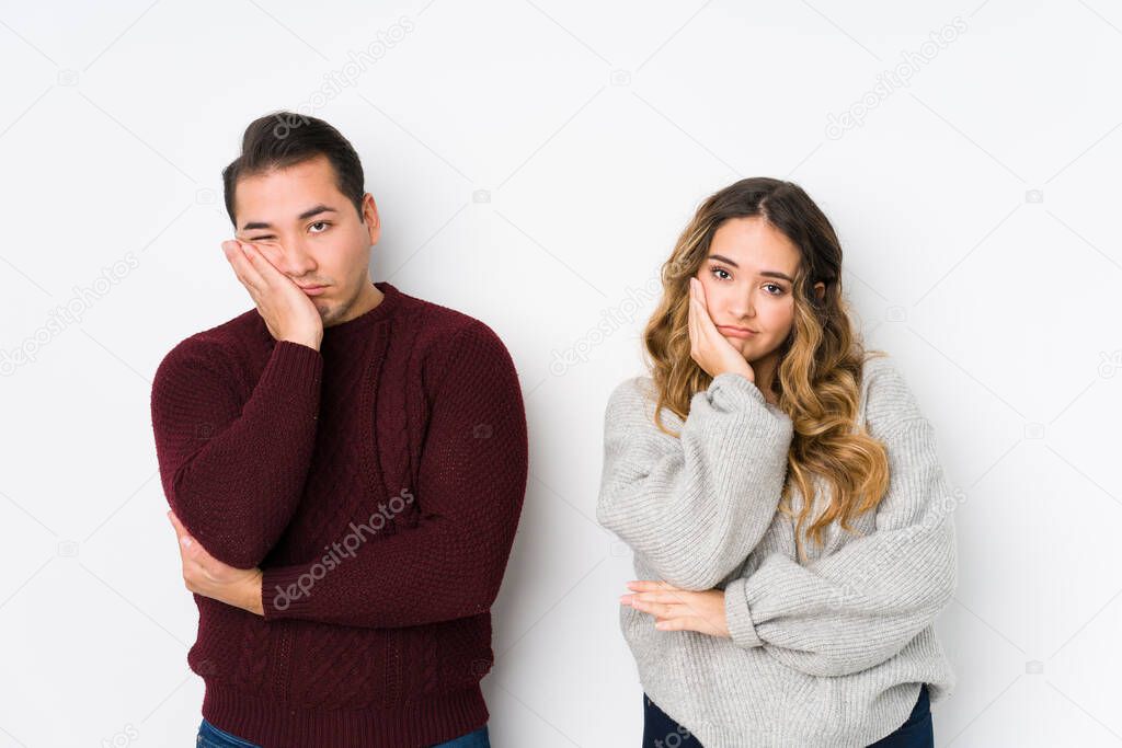Young couple posing in a white background who is bored, fatigued and need a relax day.