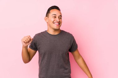 Pembe arka plan dansında poz veren Latin adam eğleniyor..