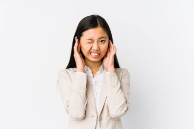 Young chinese business woman isolated covering ears with hands. clipart