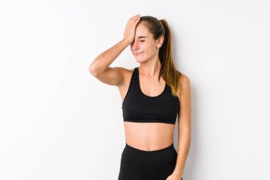 Beyaz arka planda poz veren beyaz tenli bir kadın bir şeyi unutuyor. Alnına avuç içi ve kapalı gözlerle vuruyor..