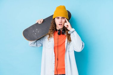 Kafkasyalı genç kaykaycı, işaret parmağıyla hayal kırıklığı jesti yapıyor..