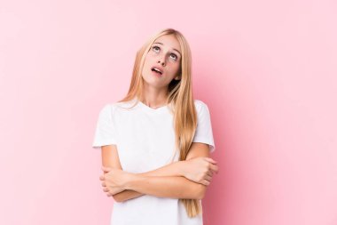 Pembe arka plandaki genç sarışın kadın tekrarlanan bir görevden yoruldu..