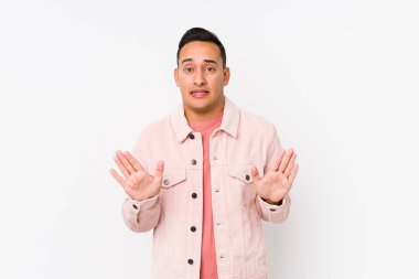 Genç latin adam dışlanmış poz veriyor. İğrenme hareketi gösteren birini reddediyor..