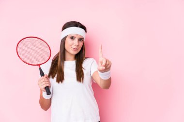 Badminton oynayan beyaz bir kadın bir numarayı parmağıyla gösterdi..