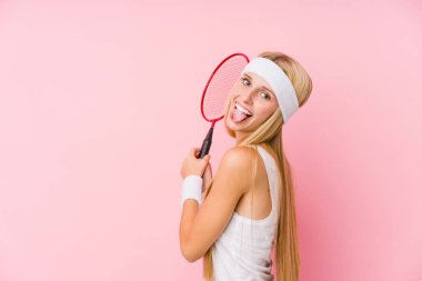 Yalnız başına badminton oynayan genç sarışın kadın.