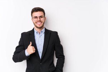 Beyaz arka planda poz veren beyaz tenli genç beyaz iş adamı, gülümseyen ve başparmağını kaldıran beyaz tenli genç bir iş adamı izole etti.