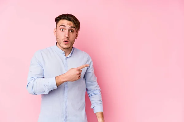 Jonge Blanke Man Poseren Een Roze Achtergrond Geïsoleerd Wijzend Naar — Stockfoto