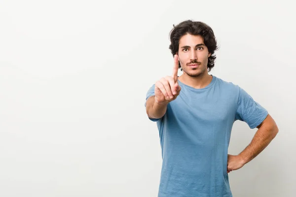 Jonge Knappe Man Tegen Een Witte Achtergrond Tonen Nummer Een — Stockfoto