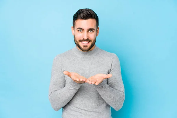 Joven Hombre Caucásico Sobre Fondo Azul Aislado Sosteniendo Algo Con —  Fotos de Stock