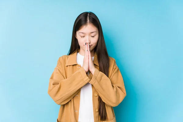 Mladá Číňanka Pózující Modrém Pozadí Izolované Držení Ruce Modlitbě Blízko — Stock fotografie