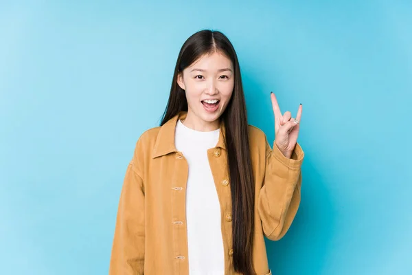 Young Chinese Woman Posing Blue Background Isolated Showing Horns Gesture — 스톡 사진