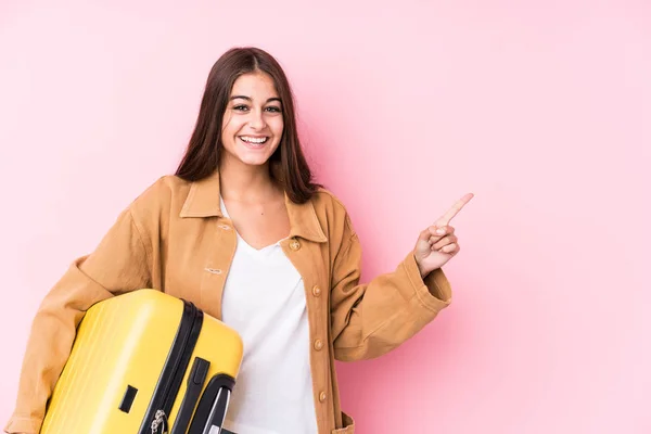 Joven Viajera Caucásica Sosteniendo Una Maleta Aislada Sonriendo Señalando Lado — Foto de Stock