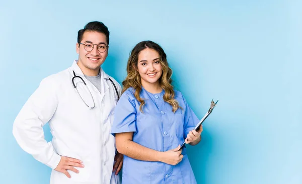 Giovane Coppia Medico Posa Uno Sfondo Blu Isolato Fiducioso Mantenendo — Foto Stock