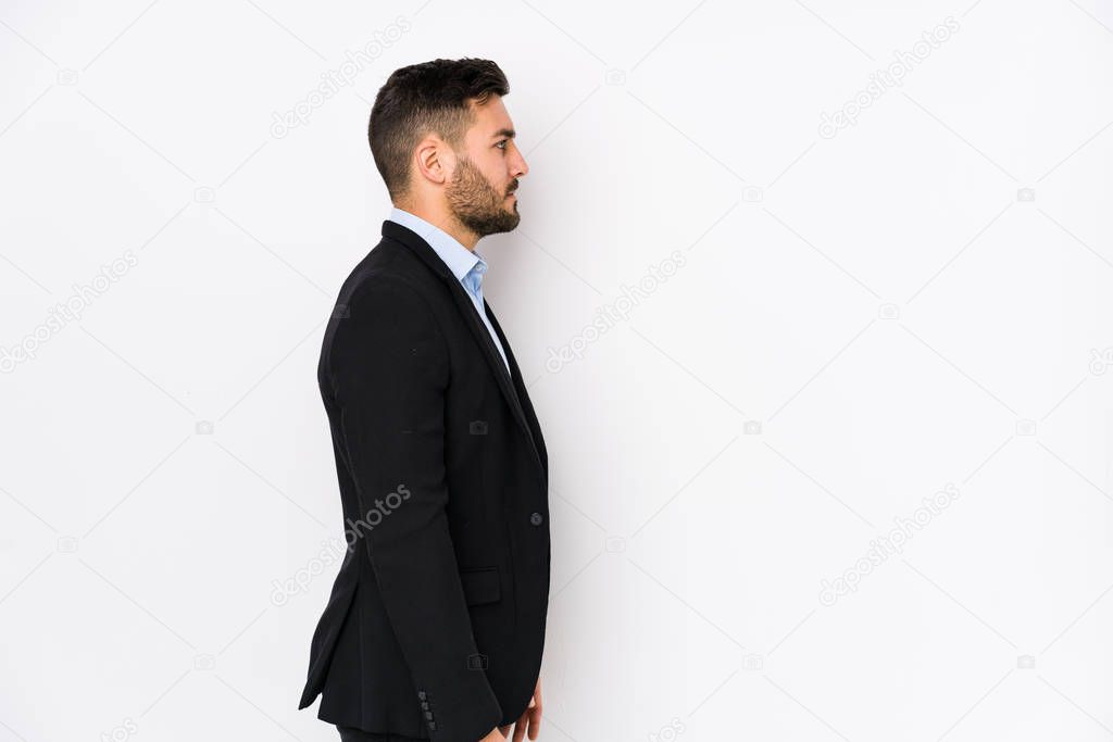 Young caucasian business man against a white background isolated gazing left, sideways pose.