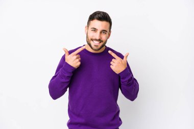 Beyaz arka planda beyaz tenli genç bir adam izole edilmiş gülücükler, dudaklarını işaret ediyor..