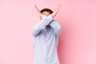 Pembe arka planda poz veren beyaz bir genç iki kolu çapraz tutuyor, inkar kavramını koruyor..