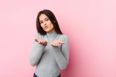 Dudaklarını kıvıran ve hava öpücüğü vermek için avuçlarını tutan hoş bir kadın..