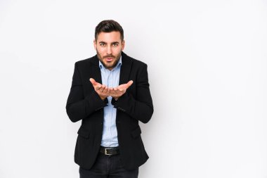 Young caucasian business man against a white background isolated folding lips and holding palms to send air kiss.