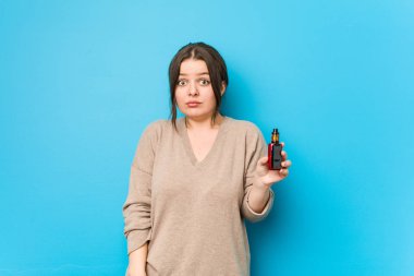 Buharlaştırıcı tutan genç kıvrımlı kadın omuzlarını silker ve gözleri açık kalır..