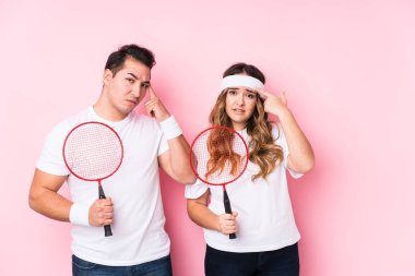 Badminton oynayan genç çift işaret parmağıyla bir hayal kırıklığı gösteriyor..