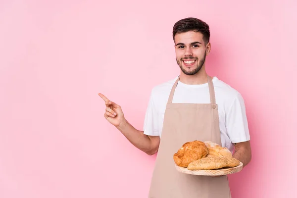 Junger Kaukasischer Bäcker Isoliert Lächelnd Und Zur Seite Zeigend Etwas — Stockfoto