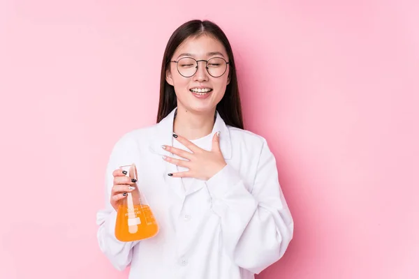 Young chinese scientific woman isolated laughs out loudly keeping hand on chest.