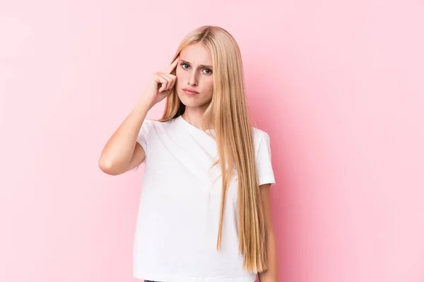 Ung Blond Kvinne Med Rosa Bakgrunn Som Peker Tempel Med – stockfoto