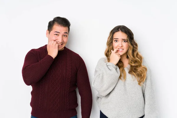 Casal Jovem Posando Fundo Branco Mordendo Unhas Nervoso Muito Ansioso — Fotografia de Stock