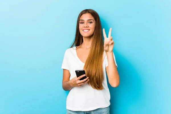 Joven Mujer Caucásica Sosteniendo Teléfono Mostrando Número Dos Con Los — Foto de Stock