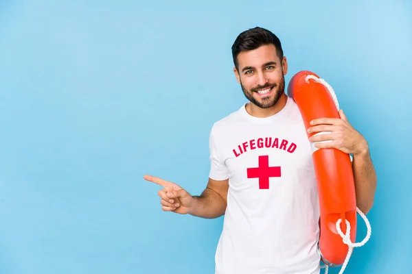 Joven Hombre Salvavidas Guapo Isoalted Sonriendo Señalando Lado Mostrando Algo —  Fotos de Stock