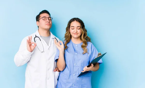 Young Doctor Couple Posing Blue Background Isolated Relaxes Hard Working — 스톡 사진