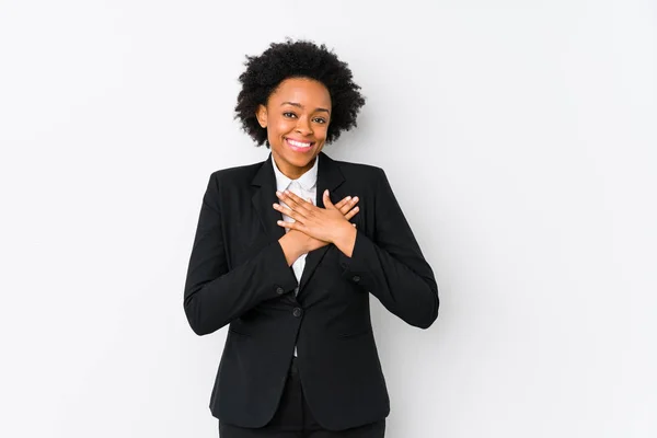 白人の背景が孤立したアフリカ系アメリカ人のビジネス女性はフレンドリーな表情をしており 手のひらを胸に押し付けている 愛の概念 — ストック写真