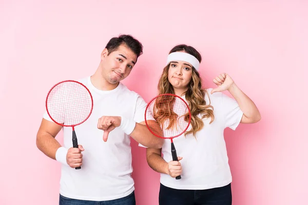 Casal Jovem Jogando Badminton Isolado Mostrando Gesto Antipatia Polegares Para — Fotografia de Stock
