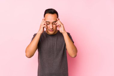 Pembe arka planda poz veren latin adam tapınaklara dokunuyor ve baş ağrısı çekiyor..