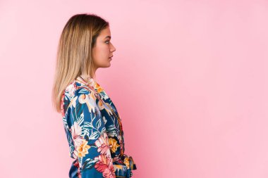 Genç beyaz kadın pijama giyiyor, sola bakıyor, yan pozlar veriyor..