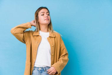 Beyaz bir kadın başının arkasına dokunuyor, düşünüyor ve bir seçim yapıyor..