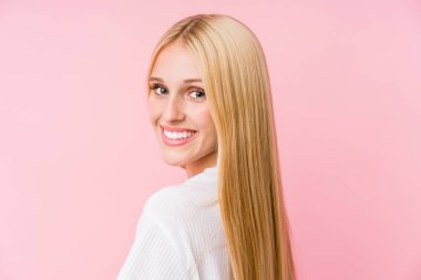 Pembe arka planda soyutlanmış genç sarışın kadın yüzü.