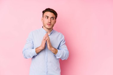 Pembe arka planda poz veren Kafkasyalı genç bir adam... -... bir plan hazırlıyor..