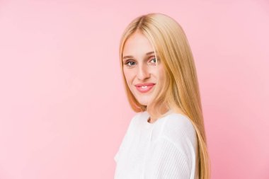Pembe arka planda soyutlanmış genç sarışın kadın yüzü.