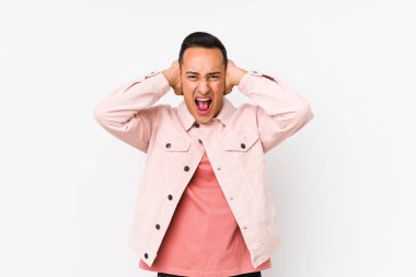 Genç latin adam yalnız poz veriyor. Kulakları kapalı, yüksek sesli sesler duymamaya çalışıyor..