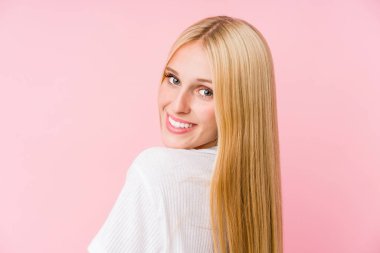 Pembe arka planda soyutlanmış genç sarışın kadın yüzü.