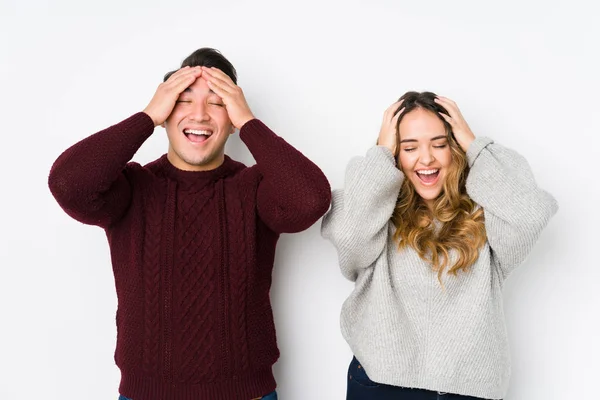 Young Couple Posing White Background Laughs Joyfully Keeping Hands Head — 스톡 사진