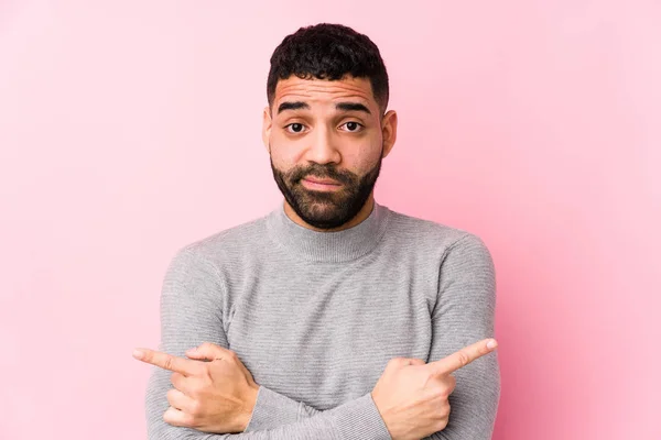 Homem Latino Jovem Contra Fundo Rosa Pontos Isolados Lateralmente Está — Fotografia de Stock