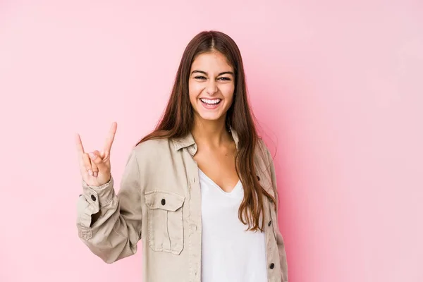 Giovane Donna Caucasica Posa Uno Sfondo Rosa Mostrando Gesto Corna — Foto Stock